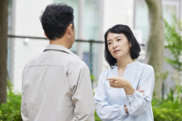 夫婦喧嘩する中年の夫婦　屋外