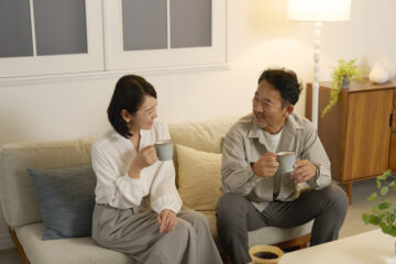 夜のリビングで会話する日本人熟年夫婦